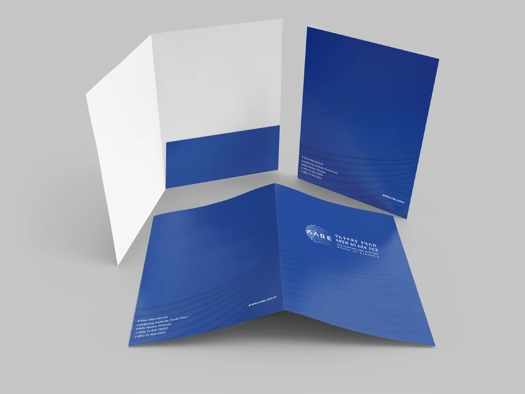 An AABE presentation folder standing open, blue outside with the pattern, white inside.