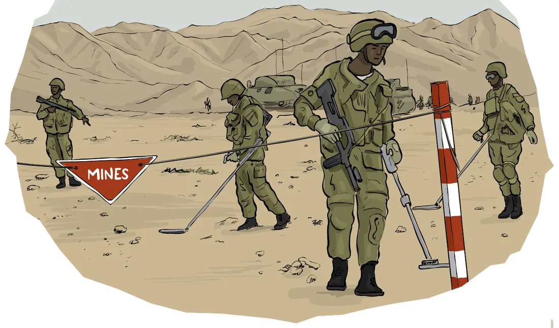 Soldiers in protective gear sweep a desert minefield with detectors behind a red triangular Mines sign.