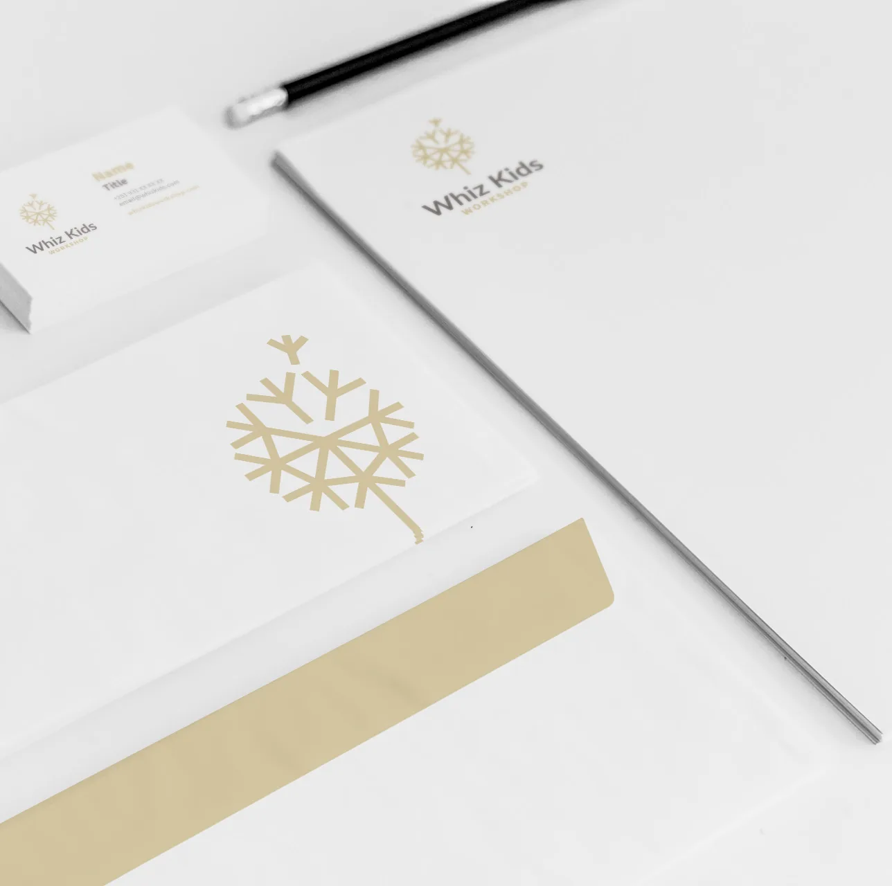 White Whiz Kids stationery with business cards and a large gold dandelion on a letter.