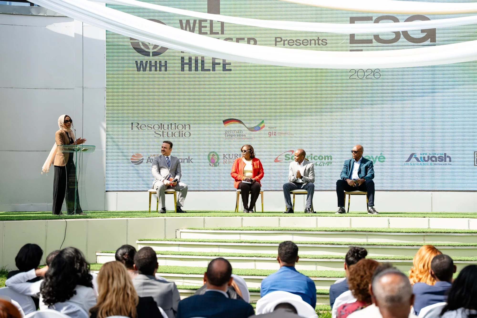 The ESG Forum stage: a speaker at the lectern beside four panelists, the audience in the foreground.
